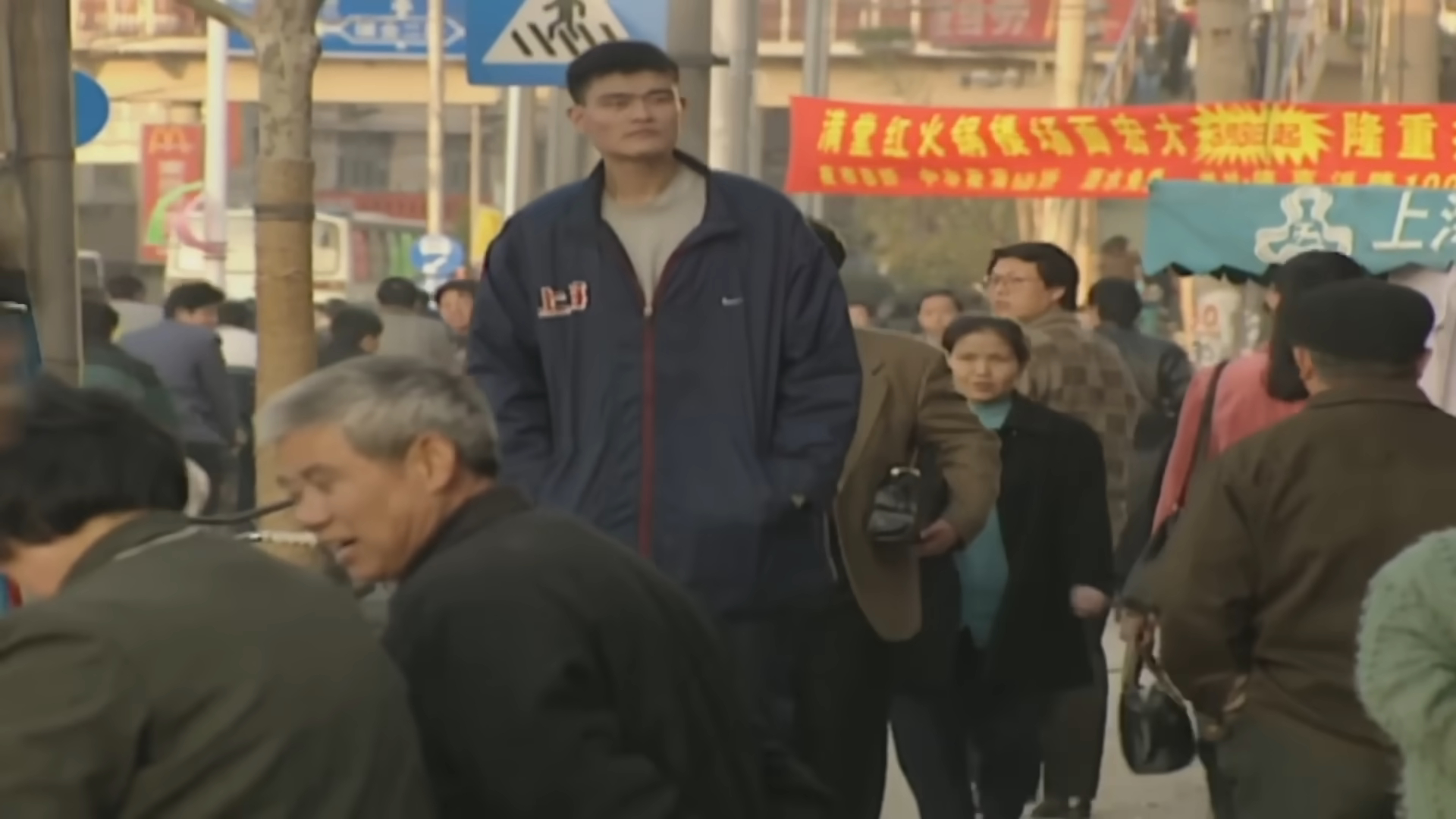 Yao Ming walking down the street and being evidently taller than the rest of the people
